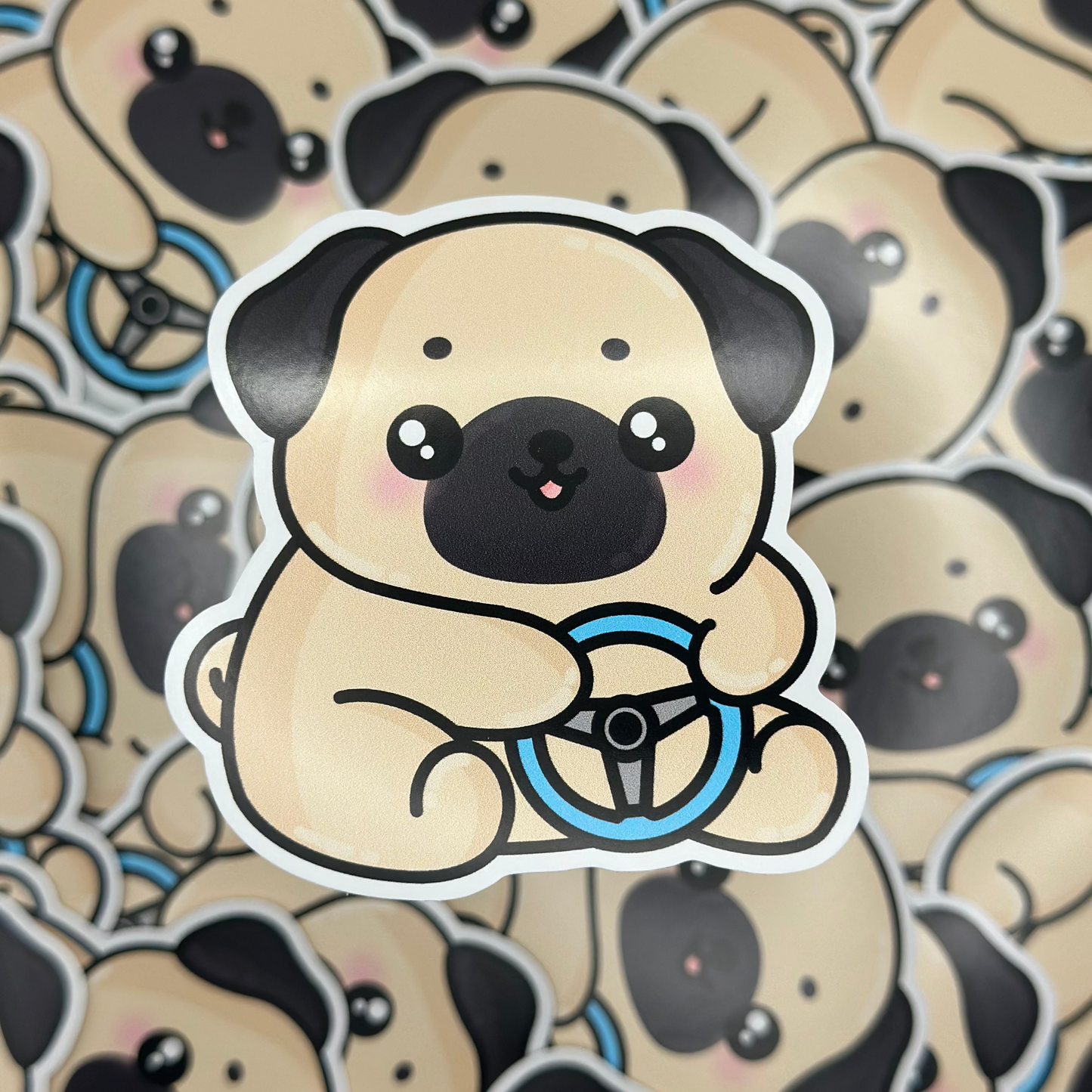 Sticker of a pug holding a blue steering wheel on a background of similar pug stickers.