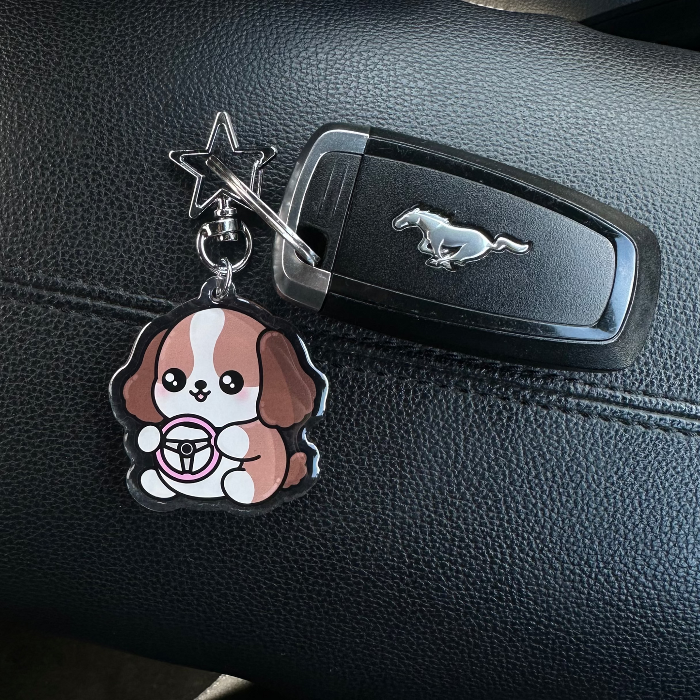 Car key with a dog-shaped keychain on a car dashboard