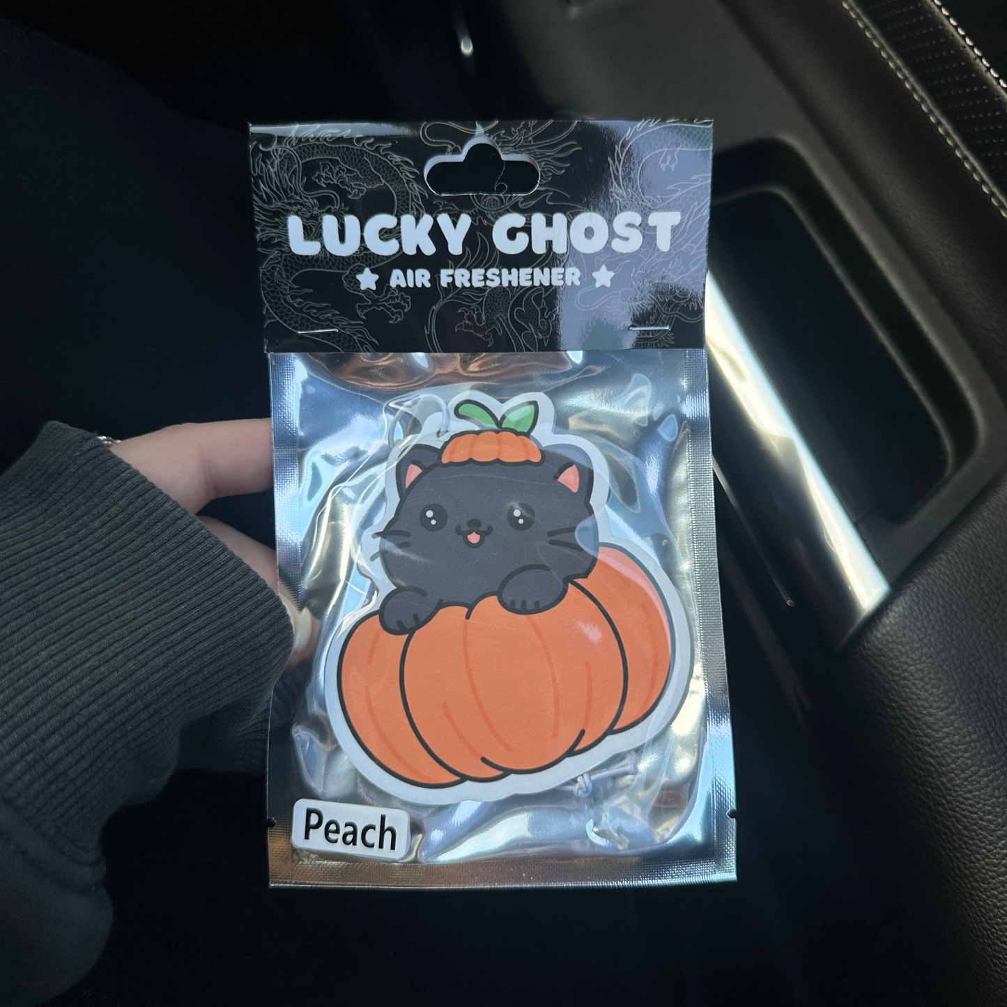 Lucky Ghost air freshener packaging with a black cat on a pumpkin design.