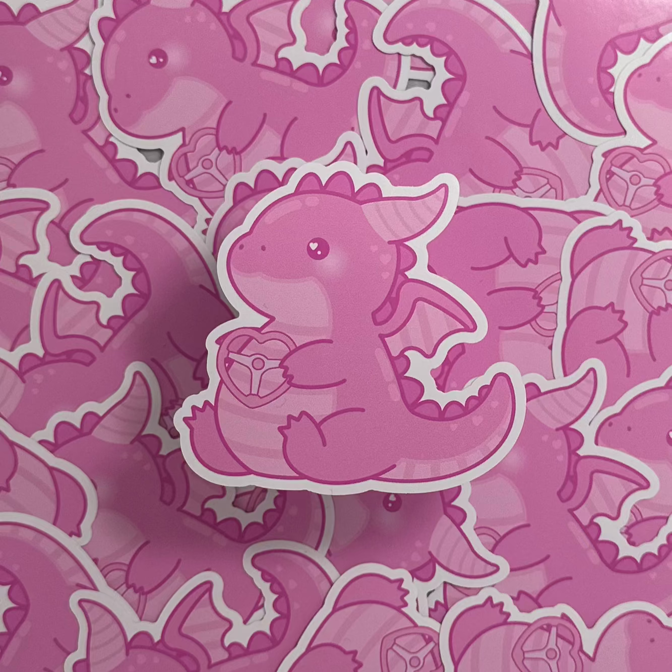 A collection of pink die-cut stickers featuring a cute, cartoon-style dragon design.