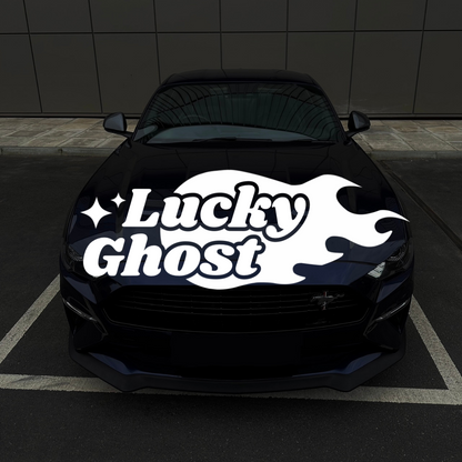 Black car with 'Lucky Ghost' decal on a dark tiled floor