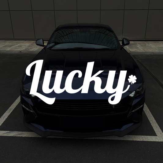 Black car with 'Lucky' decal on a dark tiled wall background