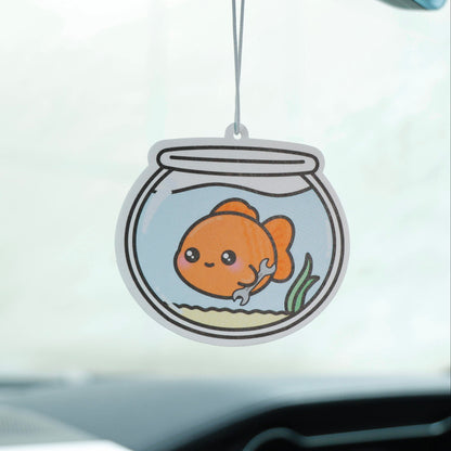 Car air freshener with a goldfish design hanging from a car's dashboard.