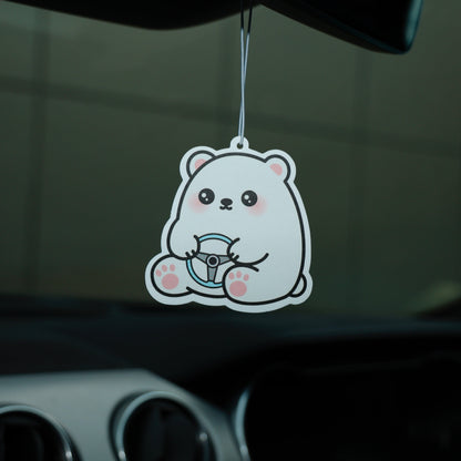 Cartoon bear air freshener hanging from a car's rearview mirror.