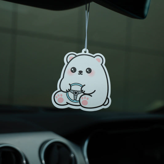 Cartoon bear air freshener hanging from a car's rearview mirror.