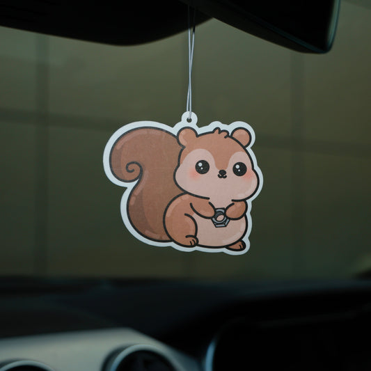 Car air freshener shaped like a squirrel hanging from a car's rearview mirror.