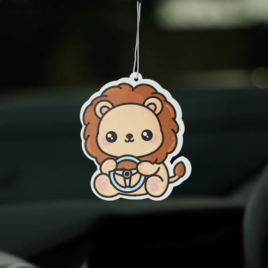 Car air freshener shaped like a lion hanging from a car's rearview mirror.
