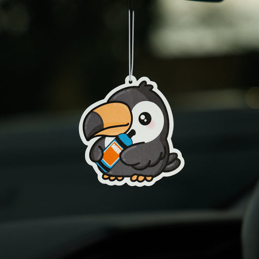 Cartoon penguin air freshener hanging from a car's rearview mirror.
