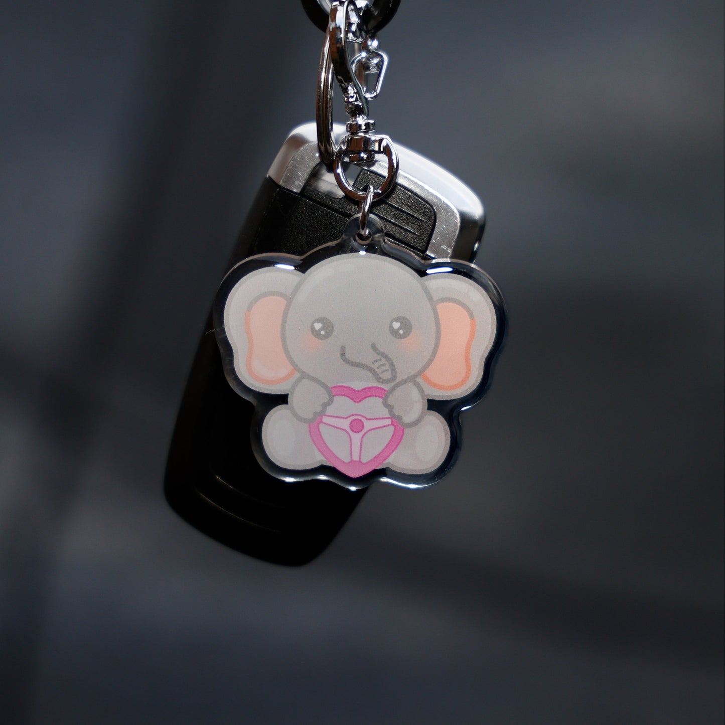 Keychain with a cartoon elephant design on a dark background