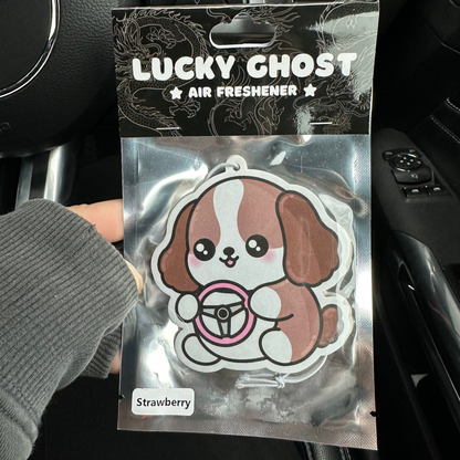 Lucky Ghost air freshener packaging held in front of a car dashboard.
