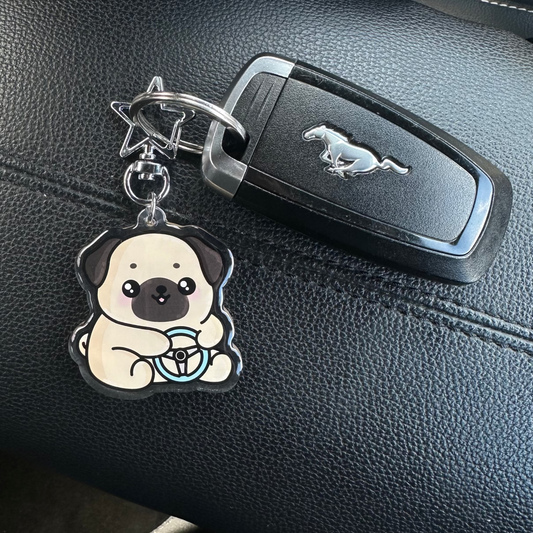 Keychain with a dog design attached to a car key on a car dashboard.
