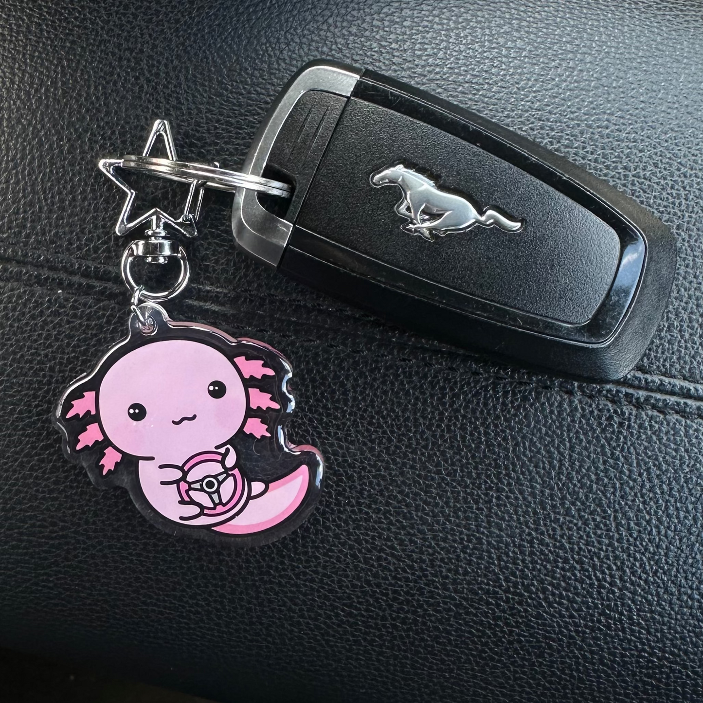 Keychain with a cartoon character on a car key fob inside a vehicle.