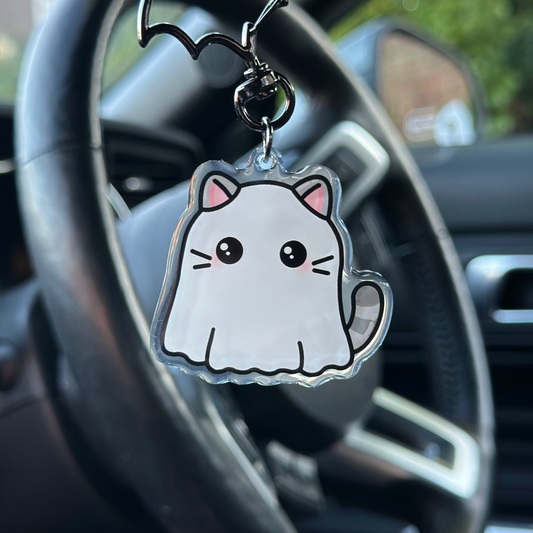 Cat-shaped keychain hanging from a car steering wheel