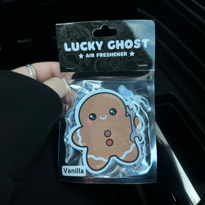 Lucky Ghost air freshener packaging with a gingerbread man design held inside a car.