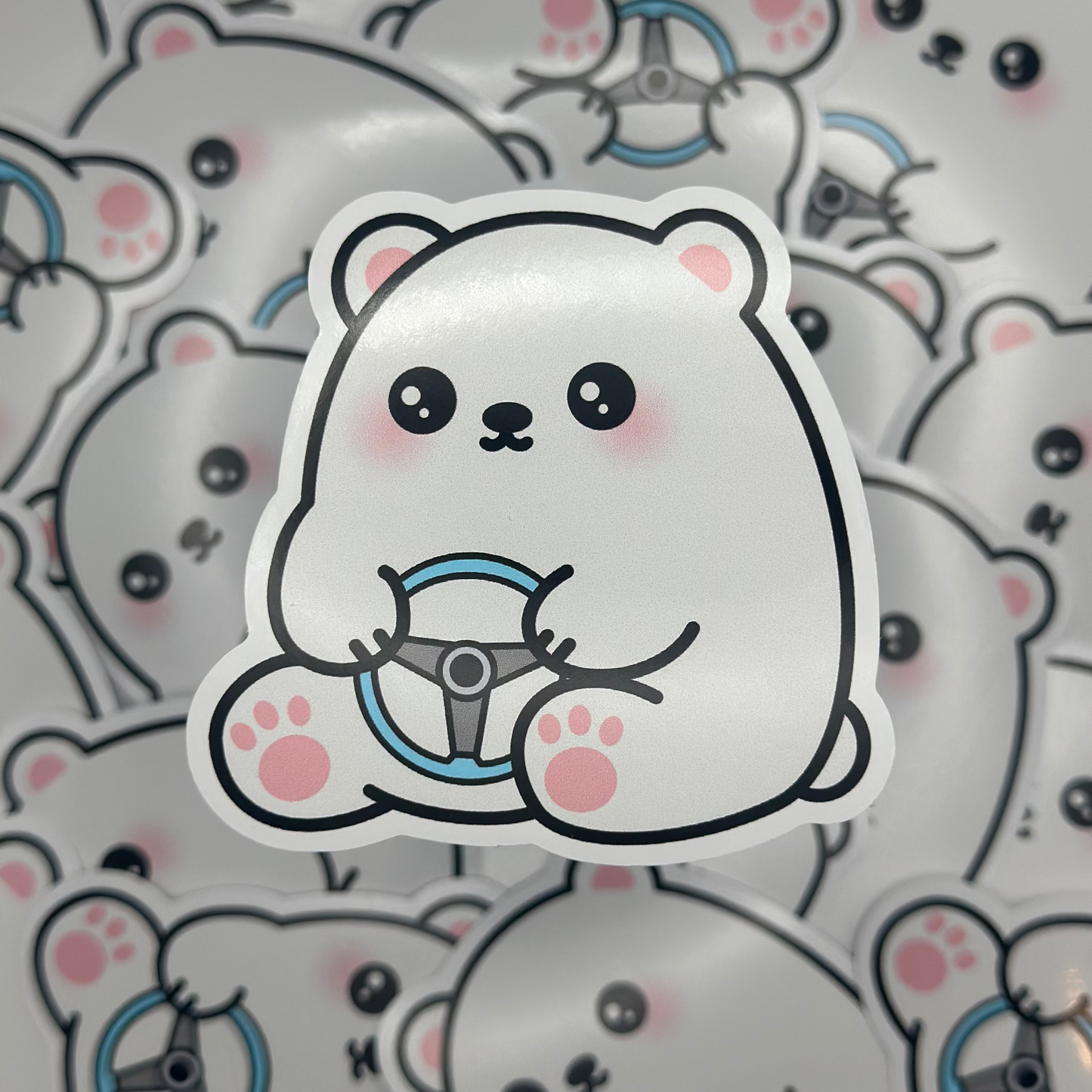 Sticker of a cute polar bear with a steering wheel on a patterned background
