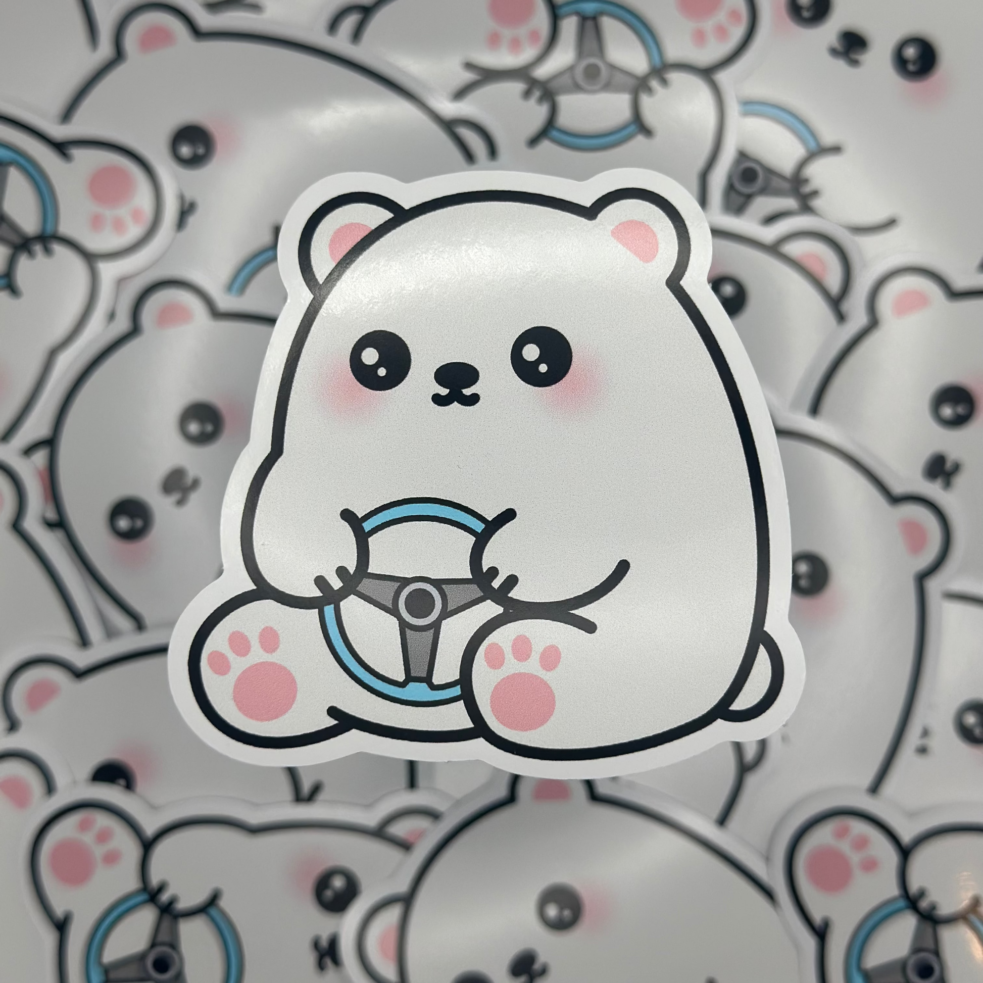 Sticker of a cute polar bear with a steering wheel on a patterned background