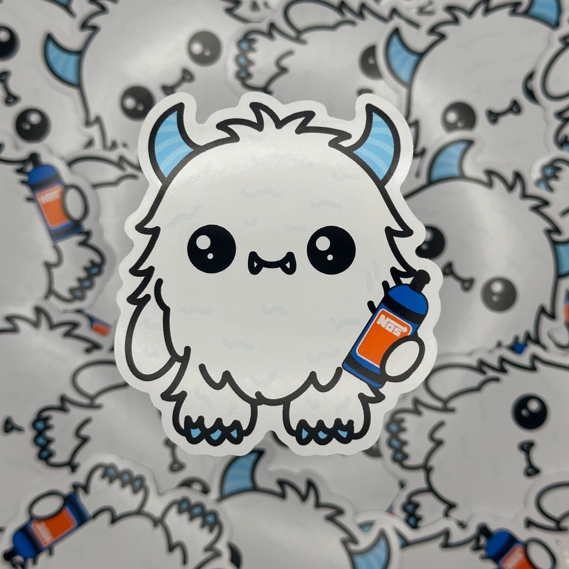 Sticker of a cute, cartoon-like creature holding a bottle on a patterned background