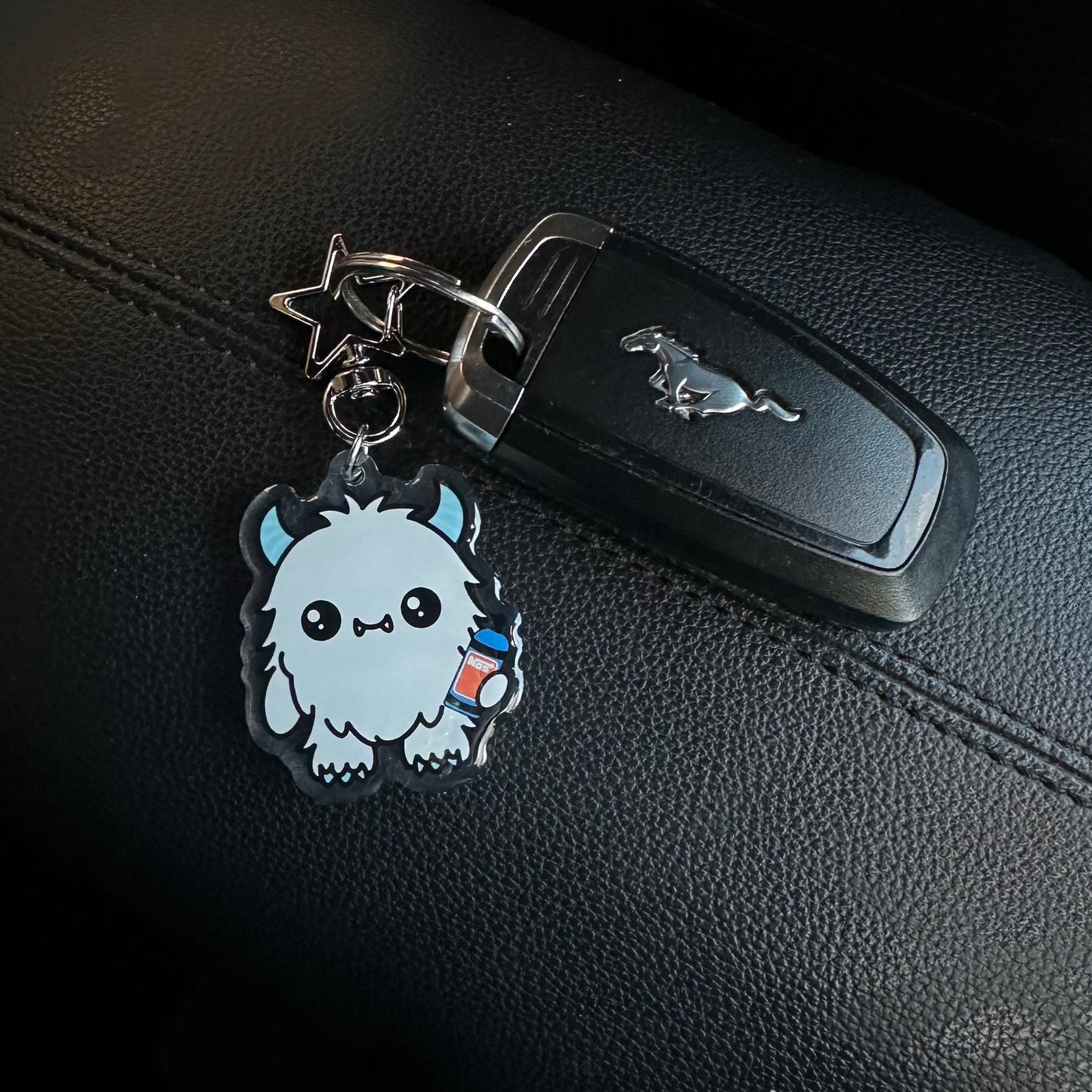 Car key with a cute animal-shaped keychain on a car seat
