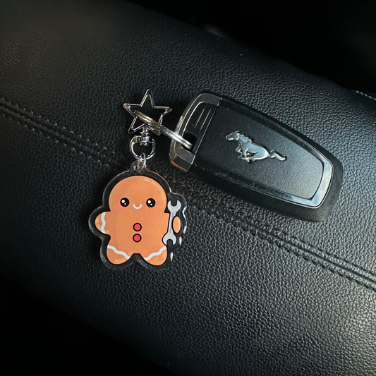 Keychain with a cartoon character attached to a car key on a black leather surface.