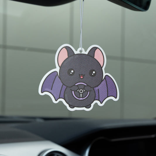 Car air freshener shaped like a bat hanging from a car's rearview mirror.