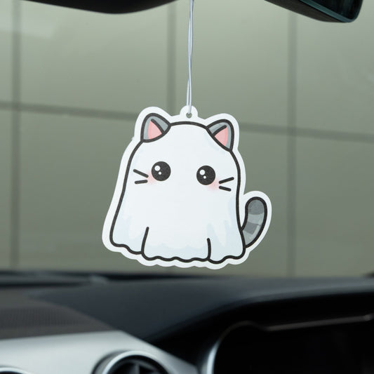 Car air freshener shaped like a cartoon cat hanging from a car's rearview mirror.